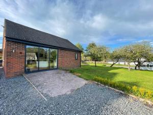 a brick house with a large glass door at The Stables,Ashley in Ashley