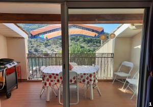 a room with a table and a balcony with a view at Appartements Hameau du Port in Esparron-de-Verdon