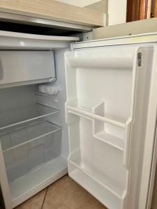 een lege koelkast met de deur open in een keuken bij Eden Appartamenti in Marina di Grosseto