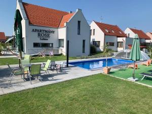 a villa with a swimming pool in front of a house at Apartmány ROSE Lednice in Lednice