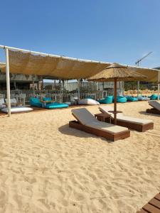 a beach with chairs and an umbrella on the sand at Villa Gracia in Ayia Napa