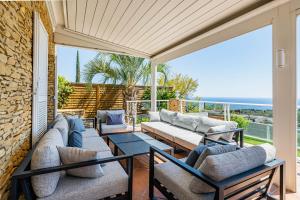 eine Terrasse mit Sofas, einem Tisch und Stühlen in der Unterkunft Villa Bellevue par Dodo-à-Cassis in Cassis