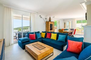 a living room with a blue couch with colorful pillows at Villa Bellevue par Dodo-à-Cassis in Cassis