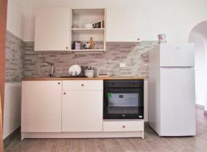 cocina con armarios blancos y nevera blanca en Clea's holiday home, en Paola