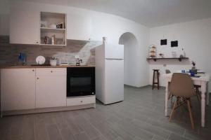 een keuken met een witte koelkast en een tafel bij Clea's holiday home in Paola