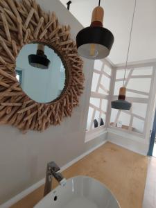ein Badezimmer mit einem Spiegel und einem Waschbecken in der Unterkunft THALASSA in Livadia