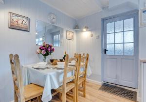 a dining room with a table and chairs and a window at Seashell Cottage in Whitby