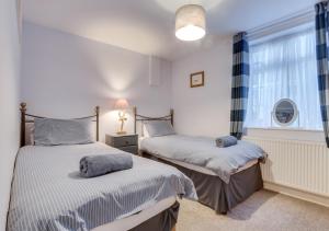 a bedroom with two beds and a window at Seashell Cottage in Whitby