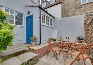 a patio with a table and chairs in front of a house at Seashell Cottage in Whitby