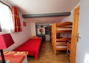 a bedroom with two bunk beds and a red couch at Appartements Hameau du Port in Esparron-de-Verdon