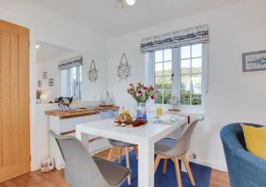 eine Küche und ein Esszimmer mit einem weißen Tisch und Stühlen in der Unterkunft Seascape Cottage in Hinderwell