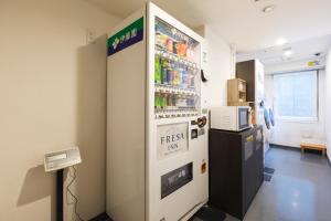 a refrigerator filled with drinks in a room at Sotetsu Fresa Inn Shimbashi Hibiyaguchi in Tokyo