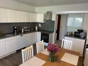 una cucina con un tavolo con un vaso di fiori sopra di Ferienwohnung Anne a Eppenrod