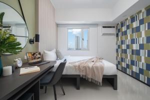 a bedroom with a bed and a desk with a laptop at The Suites at Torre Lorenzo Malate - Managed by The Ascott Limited in Manila