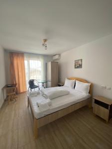 a bedroom with a large bed and a table at Kherim 2 in Tuzla