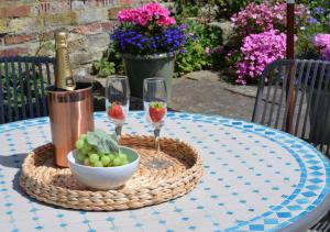 - une table avec une bouteille de vin et un bol de raisins dans l'établissement Seals Cottage, à Whitby