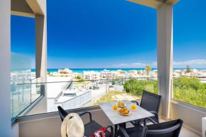 ein Balkon mit Tisch und Stühlen und Blick auf das Meer in der Unterkunft Creta Sun luxury apartments in Rethymno