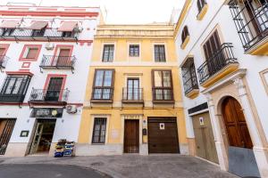 a yellow and white building with windows and doors at Exclusiva Casa en Centro in Seville