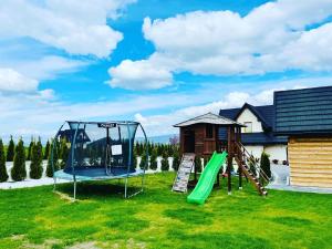 a playground with a slide and a swing set at Domki Sówka in Dursztyn