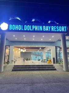 a building with a sign for a dolphin dolphin bay resort at Bohol Dolphin Bay Resort in Panglao