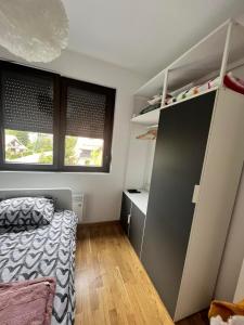 een slaapkamer met een bed, een kast en ramen bij Apartman Staša Zlatibor in Zlatibor