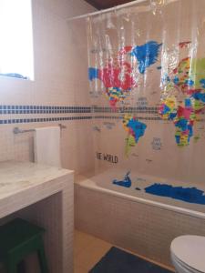 baño con un mapa del mundo en la cortina de la ducha en A casa da Laranjeira en Vale Covo