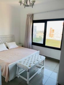 um quarto com uma cama branca e uma janela em Lovely chalet 4- bedroom directly on the lagoon em El Alamein
