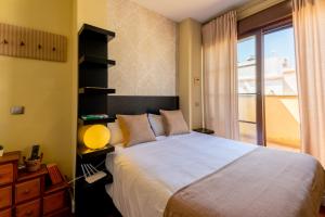 a bedroom with a large bed and a window at Exclusiva Casa en Centro in Seville