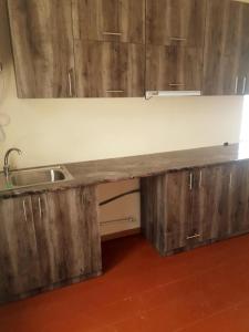 un bancone della cucina con lavello e armadi in legno di Чкалов гостевой дом a Chʼkalov