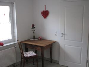 een kamer met een tafel en een hart aan de muur bij Zellerhorn in Albstadt