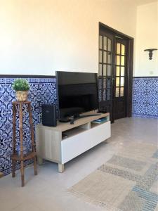 una sala de estar con TV de pantalla plana en un armario en Charming Apartment- Peniche, en Consolacao