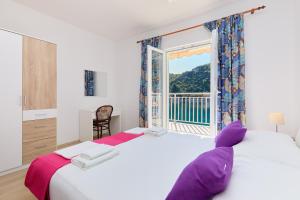 a bedroom with a large white bed and a window at Sea Song in Maranovići