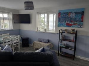 a living room with a couch and a table at Ruby's Den in Carbis Bay