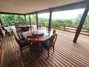 un tavolo e sedie in legno su una terrazza di Luxury Seaview Getaway a Lopes