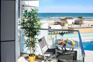 a table with a plate of food on a balcony with the beach at Vlezal Apartment Spa&Pool Beach Resort in Mamaia