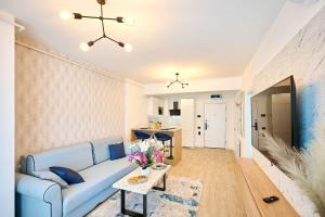 sala de estar con sofá azul y mesa en Vlezal Apartment Spa&Pool Beach Resort en Mamaia