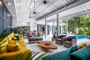 a living room with yellow and blue furniture and a pool at The Beach House in Canggu