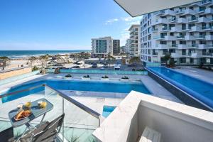 a balcony with a swimming pool and a building at Vlezal Apartment Spa&Pool Beach Resort in Mamaia