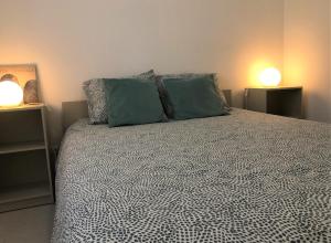 Un dormitorio con una cama grande con dos almohadas verdes. en Charming Apartment- Peniche, en Consolacao