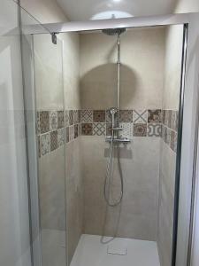 a shower with a glass door in a bathroom at Appartement Crème in Manosque