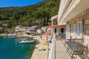 a balcony of a house with a boat in the water at Sea Song in Maranovići