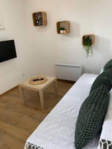 a living room with a bed and a table at Appartement Crème in Manosque