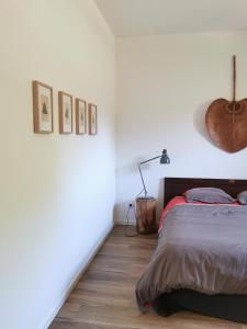 a white bedroom with a bed and a lamp at Gîte de charme au cœur de l'entre-deux-mers in Haux