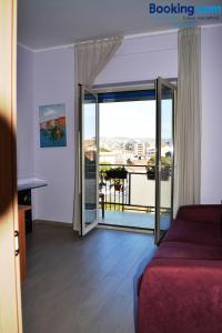 Camera con letto e porta a vetri con balcone. di Da Aloisia - Casa Vacanze a Catania