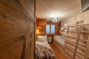 a bedroom with two bunk beds and a window at L'Atelier du Temps - Le Petit Refuge Appartement in Cogne