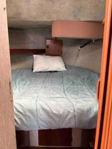 a small bed in a small room with a white pillow at Waterfront 32' Bayliner Yacht in Providence