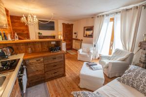 cocina y sala de estar con sofá y sillas en L'Atelier du Temps - Le Petit Refuge Appartement en Cogne