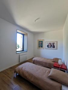a bedroom with two beds and a window at Gîte de charme au cœur de l'entre-deux-mers in Haux