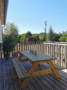 a wooden picnic table on a wooden deck at Gîte de charme au cœur de l'entre-deux-mers in Haux