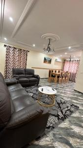 - un salon avec un canapé et une table dans l'établissement Appartement haut standing ,Biyem Assi TKC, à Yaoundé